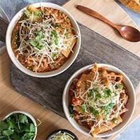 Two white bowls of Healthy Instant Pot Lasagna Soup on a wooden board