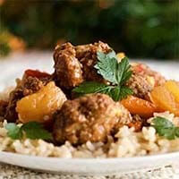 Homemade Hawaiian Meatballs over rice on a white plate