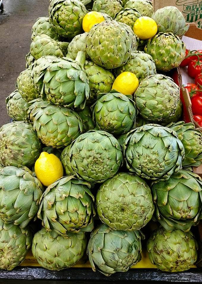 Several Artichokes stacked up with lemons at the Farmers Market