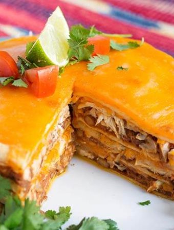 Chicken Taco Pie on a white plate with a piece removed, showing layers of pie