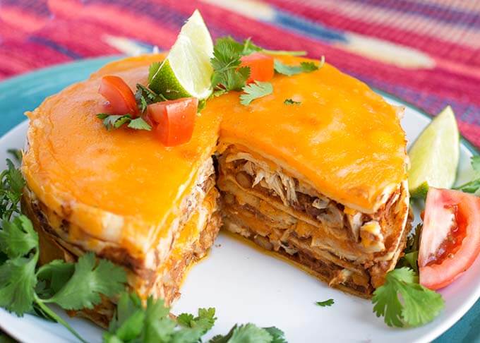 Chicken Taco Pie on a white plate with a piece removed, showing layers of pie