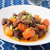 Braised Short Ribs with Daikon and Carrot on a white plate
