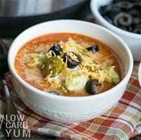 Instant Pot Low Carb Taco Soup in a white bowl in front of a pressure cooker