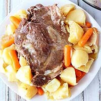 Pot Roast with carrots and potatoes on a white plate