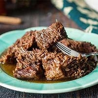 Low Carb Balsamic Beef on a blue plate with silver fork