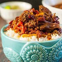 Spicy Barbacoa Beef Roast over rice in a blue bowl