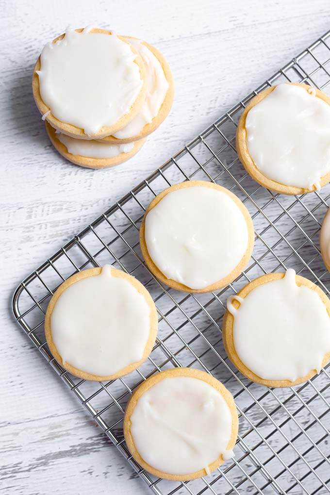 Round sugar cookies with Vanilla Icing Glaze on a wire cooling rack