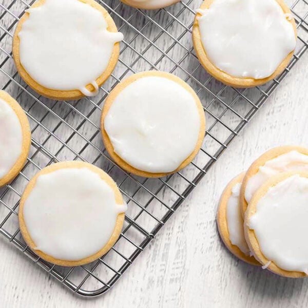 iced sugar cookies on a wire rack on a white wood board