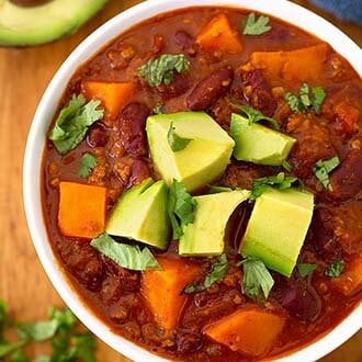 sweet potato chili in a white bowl on a wooden board