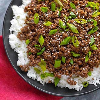 Korean Ground Beef - Bulgogi over white rice on a black plate