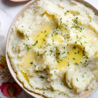 Instant Pot Mashed Cauliflower is a delicious and healthy vegetable side dish. It is easy and fast to make. Pressure cooker mashed cauliflower is easy to load up with extras like cheese, bacon, sour cream, and more! simplyhappyfoodie.com #instantpotrecipes #instantpotcauliflower #instantpotmashedcauliflower #pressurecookercauliflower