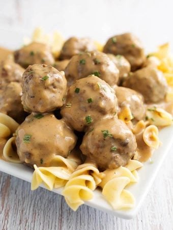 Swedish Meatballs over noodles on a white plate