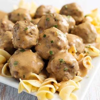 Swedish Meatballs over noodles on a white plate