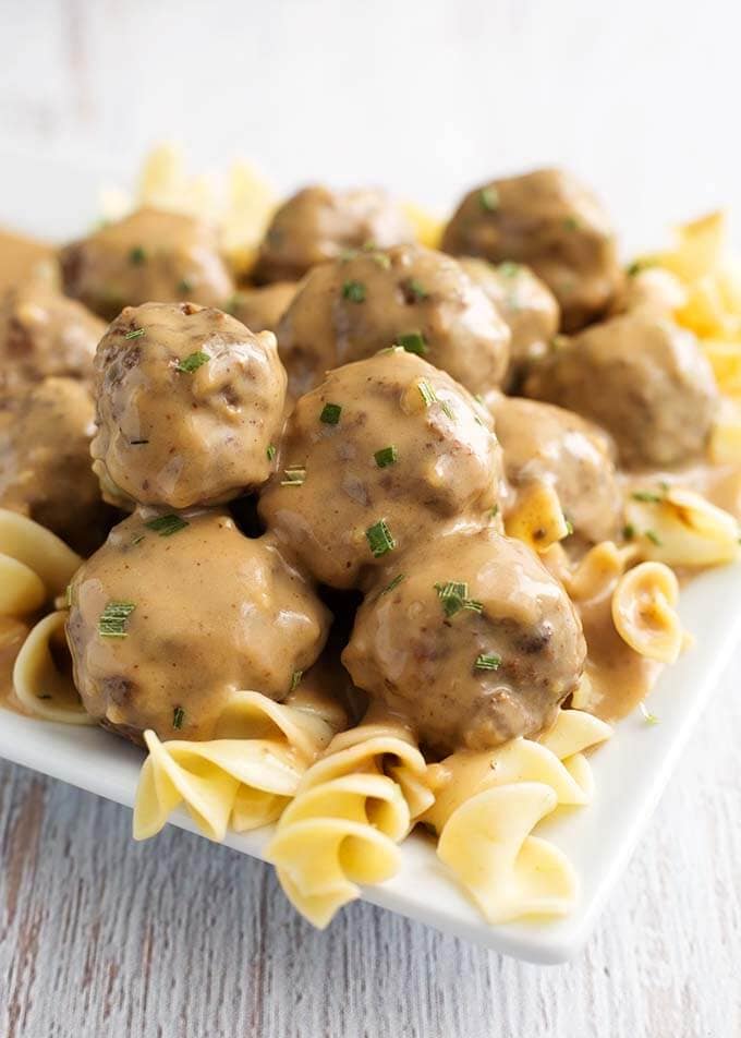 Swedish Meatballs over noodles on a white plate