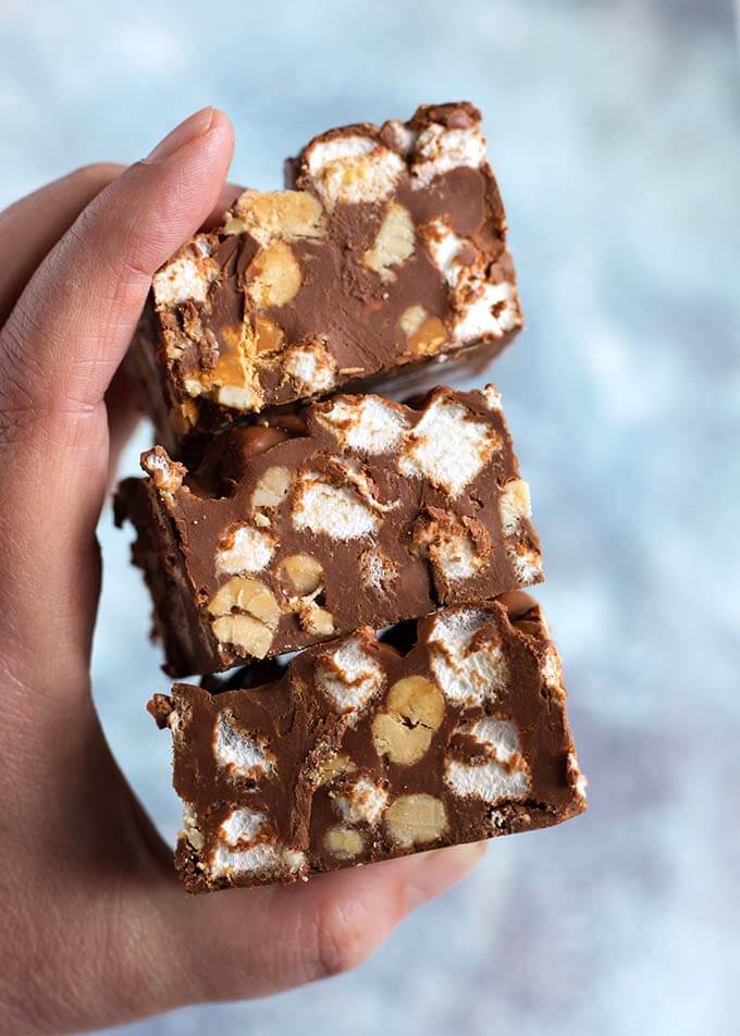 Closeup of hand holding a stack of three 5 Ingredient Chocolate Peanut Bars