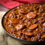 Cowboy Beans in a black bowl on a beige napkin