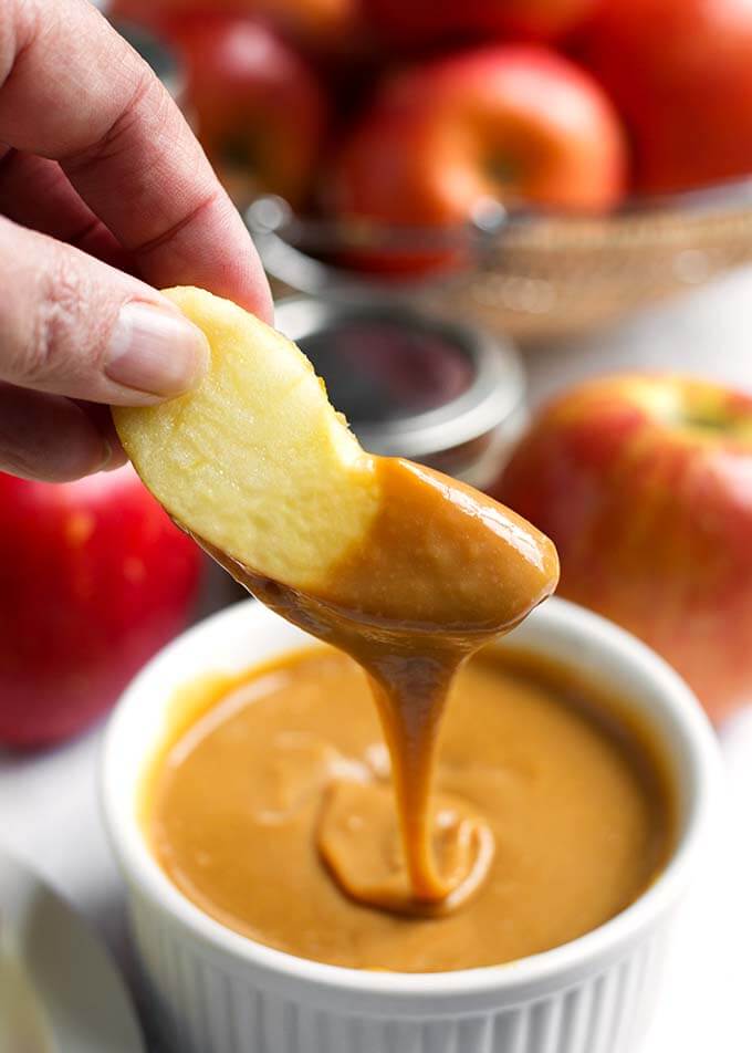 Apple slice dipped into a small bowl of Dulce de Leche Caramel