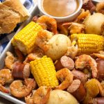 Instant Pot Low Country Shrimp Boil is a fun and super easy meal to make! Potatoes, sausage, corn and shrimp cooked together with seafood seasoning and Cajun spices. Pressure cooker low country shrimp boil is ready in a little over an hour total! Dump it on the table and dig in! simplyhappyfoodie.com #instantpotrecipes #instantpotlowcountryshrimpboil #instantpotshrimpboil #pressurecookerlowcountryboil #pressurecookershrimpboil #shrimpboil