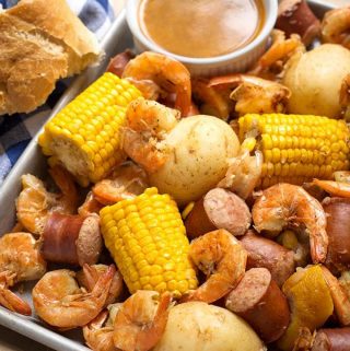 Instant Pot Low Country Shrimp Boil is a fun and super easy meal to make! Potatoes, sausage, corn and shrimp cooked together with seafood seasoning and Cajun spices. Pressure cooker low country shrimp boil is ready in a little over an hour total! Dump it on the table and dig in! simplyhappyfoodie.com #instantpotrecipes #instantpotlowcountryshrimpboil #instantpotshrimpboil #pressurecookerlowcountryboil #pressurecookershrimpboil #shrimpboil
