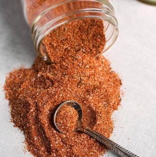 rotisserie chicken spice rub spilling out of small glass jar