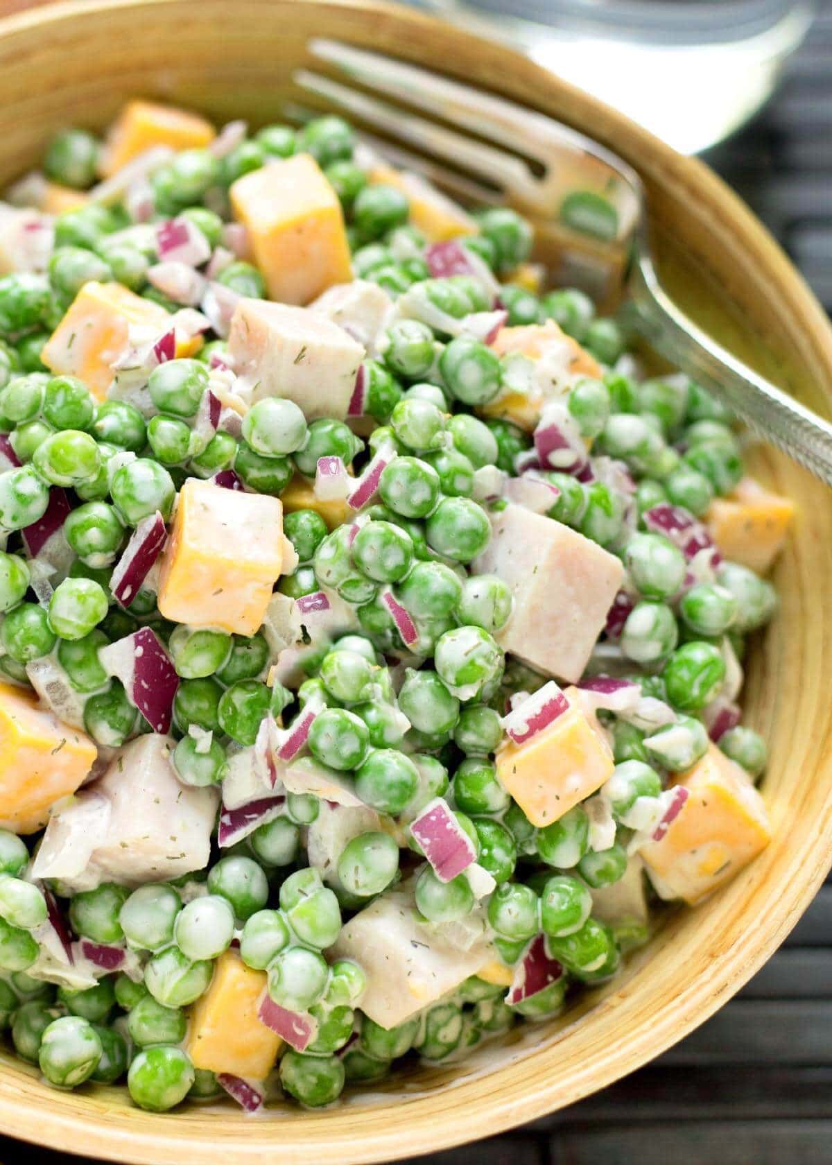Creamy Pea Salad in wood bowl with fork.