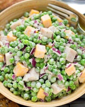 Creamy Pea Salad in a wood bowl with fork.