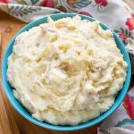 Creamy Mashed Potatoes in a blue bowl on a wooden board