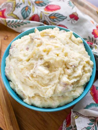 Creamy Mashed Potatoes in a blue bowl on a wooden board