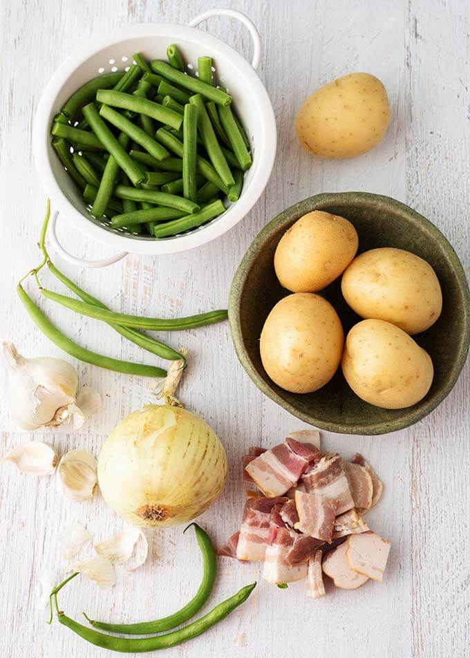 Ingredients for Green Beans with New Potatoes and Bacon on a white wood background