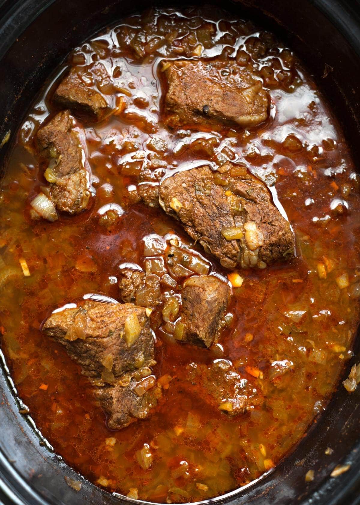 Top view of Barbacoa Beef in a black slow cooker