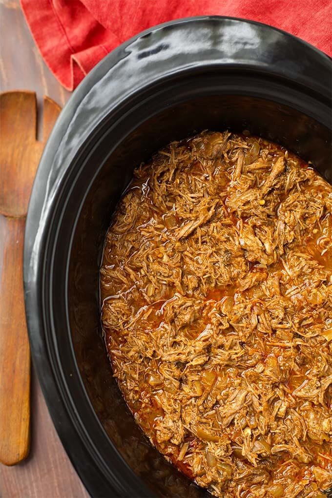 Top view of Barbacoa Beef in a black slow cooker