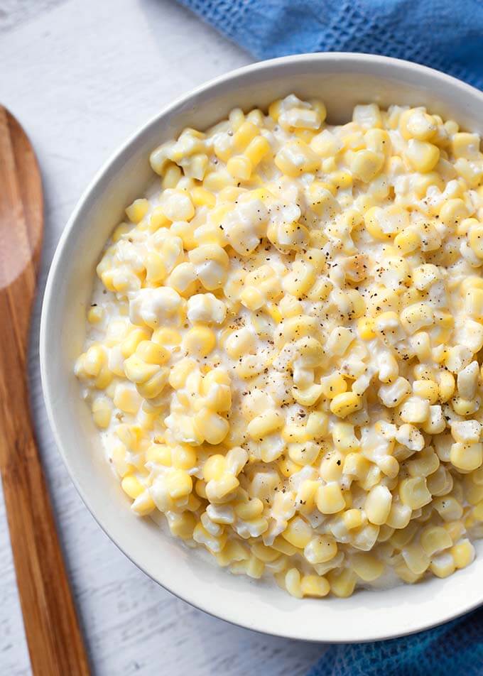 Slow Cooker Creamed Corn is one of my favorite vegetable side dishes. The creaminess and sweet corn flavor make this crock pot creamed corn much better than the canned stuff. simplyhappyfoodie.com #slowcookercreamedcorn #crockpotcreamedcorn #creamedcorn