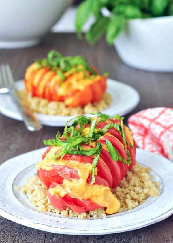 Two white pates of Cheesy Roasted Hasselback Tomatoes