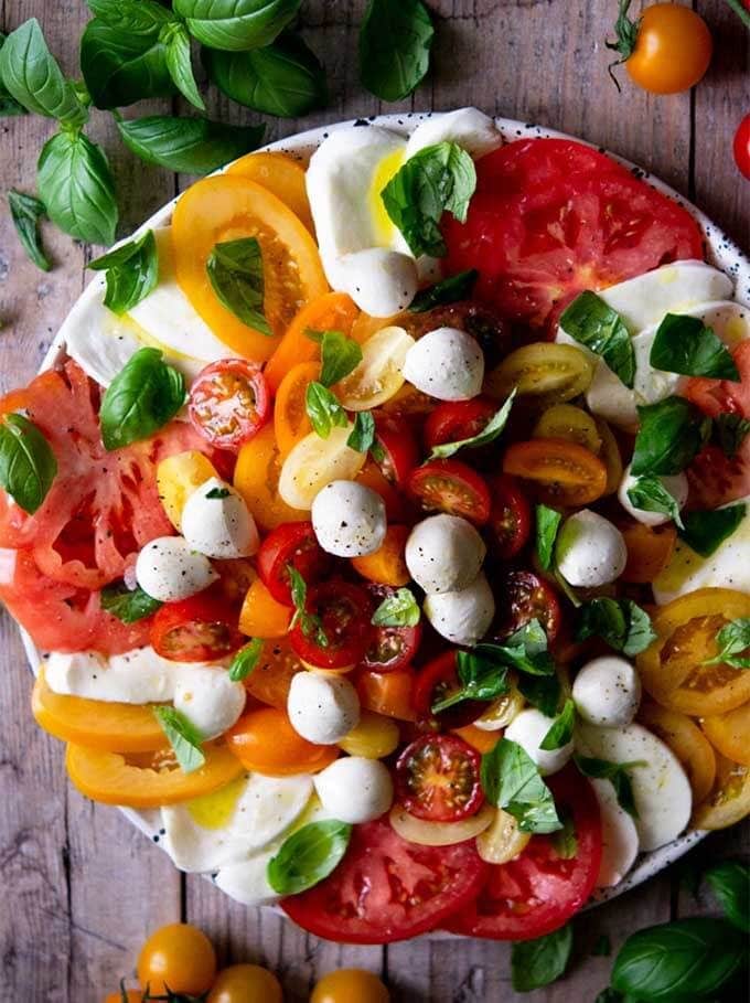 Classic Caprese Salad on a white plate on a wooden background