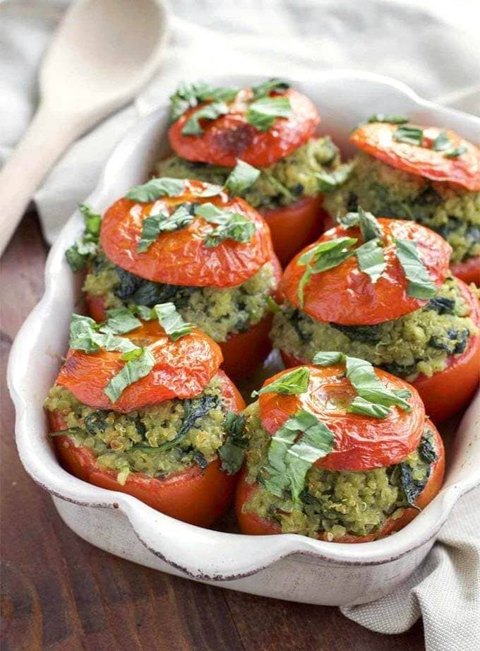 Six Pesto Spinach Quinoa Stuffed Tomatoes in a white baking dish