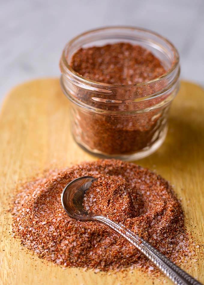 Baked chicken spice rub on a cutting board with a teaspoon