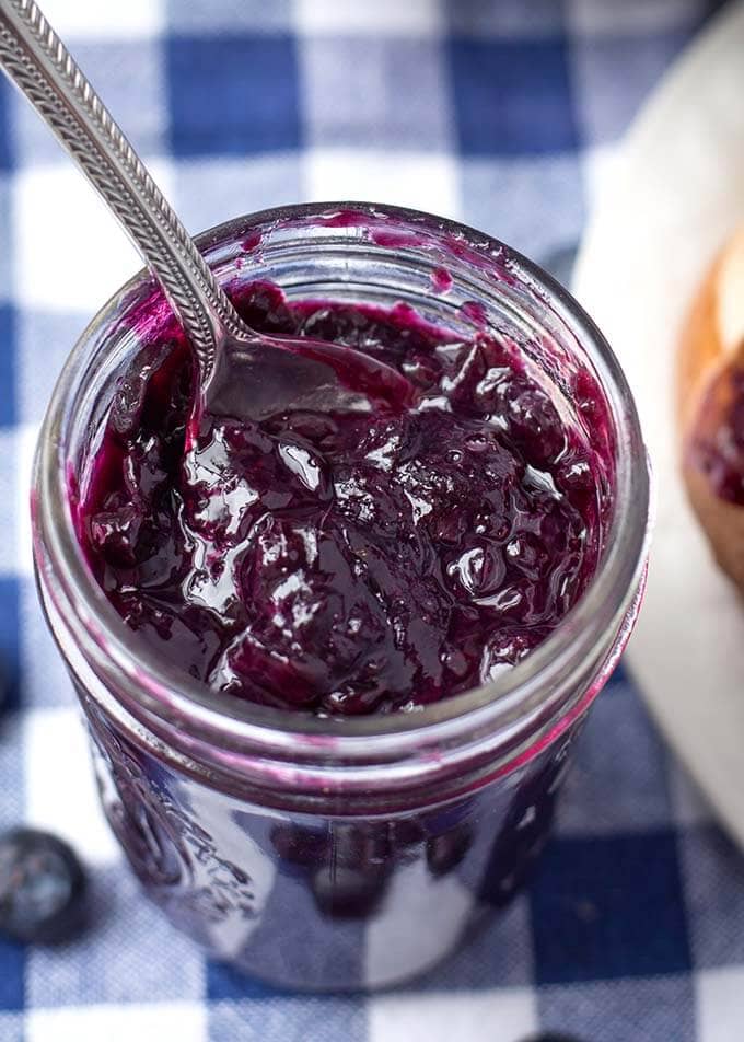 closeup of blueberry jam with a silver spoon