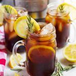 three glasses of iced tea on a table in front of a pressure cooker