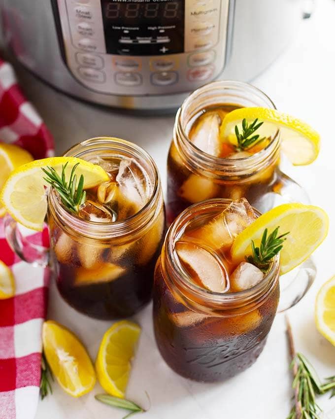 top view of three glasses of iced tea from above on a table in front of a pressure cooker