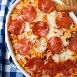 Pizza Pasta Casserole in a white oblong baking dish in front of a pressure cooker