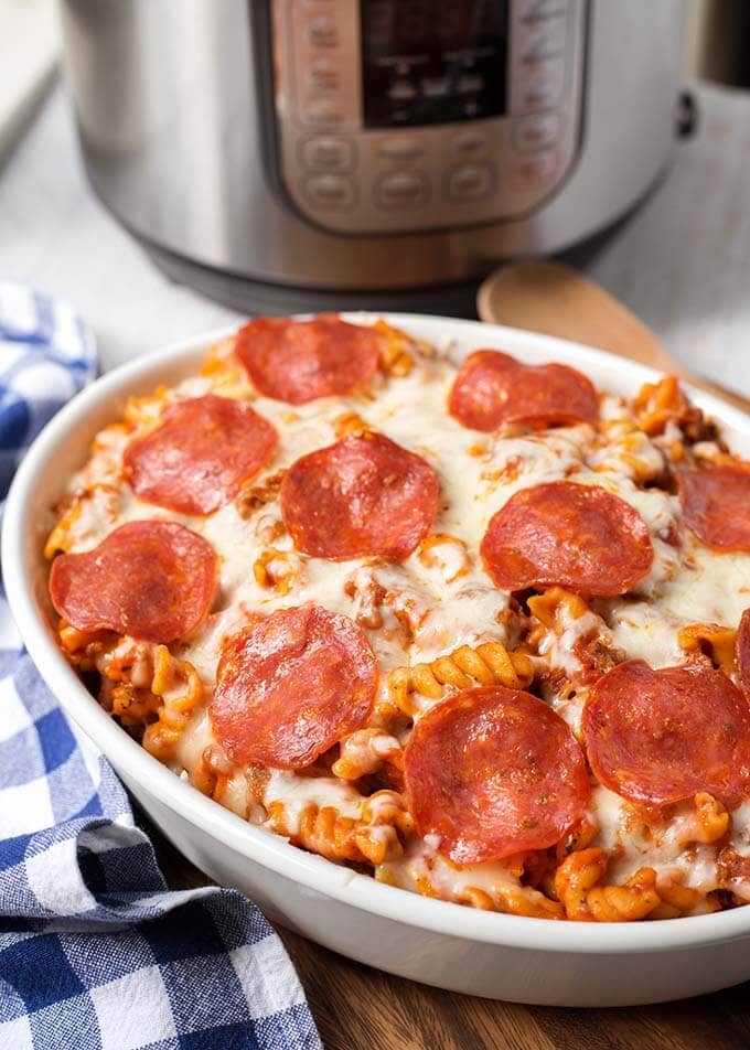 White oblong baking dish of Pizza Pasta Casserole in front of a pressure cooker