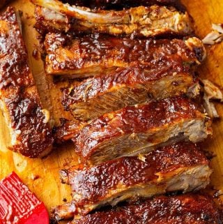 Ribs covered in Barbecue Sauce on a wooden cutting board