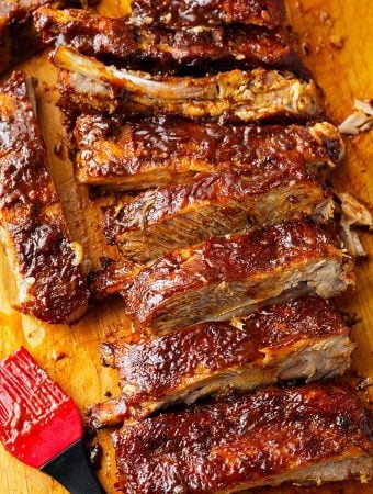 Ribs covered in Barbecue Sauce on a wooden cutting board