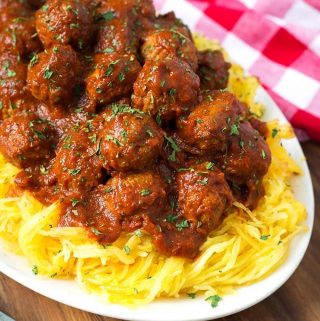 Spaghetti Squash and Meatballs on a white plate next to a red gingham napkin