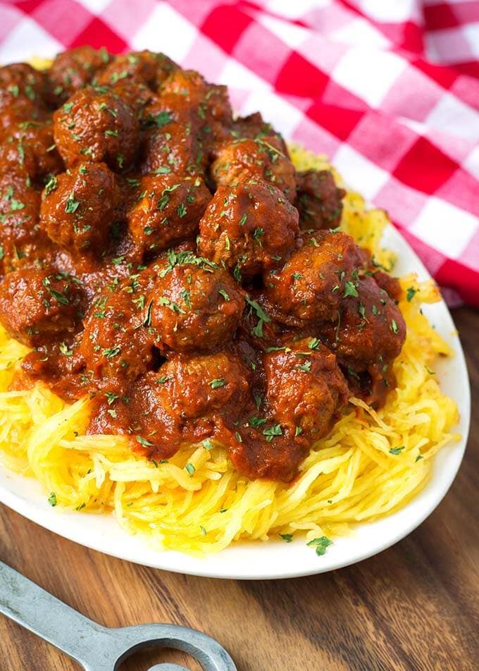 Spaghetti Squash and Meatballs on a white plate next to a red gingham napkin