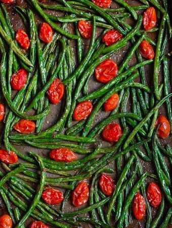 Spicy roasted green beans and tomatoes on a baking sheet