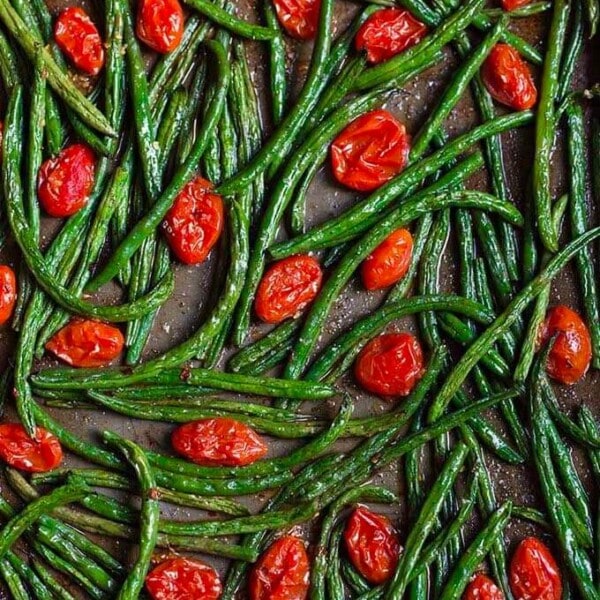 Spicy roasted green beans and tomatoes on a baking sheet
