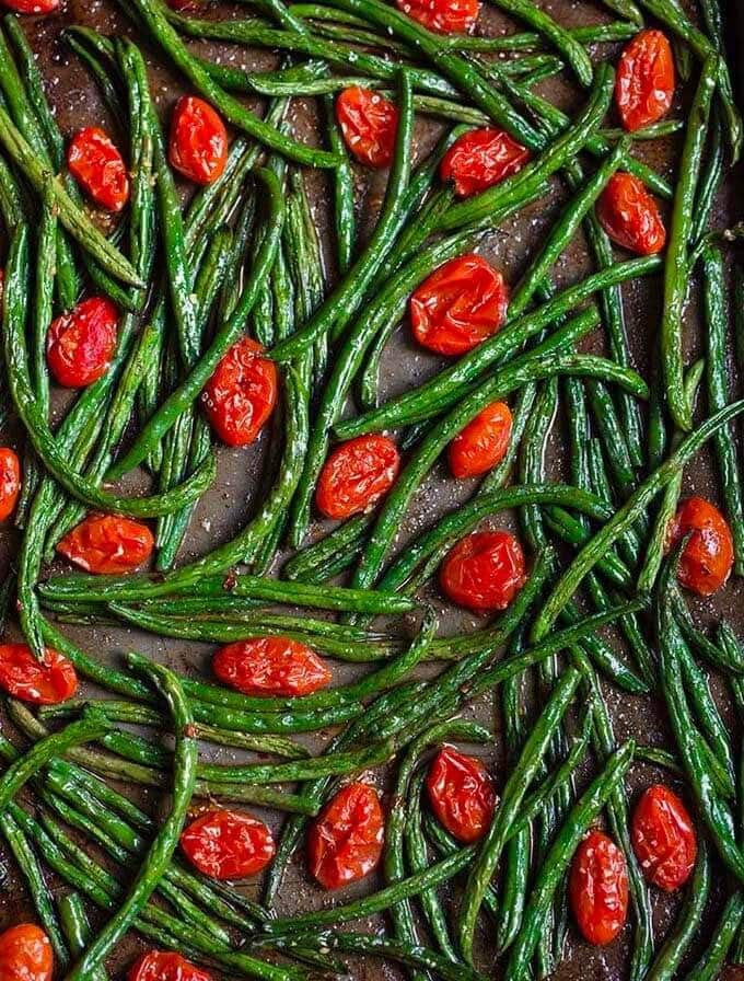 spicy roasted green beans tomatoes on a baking sheet