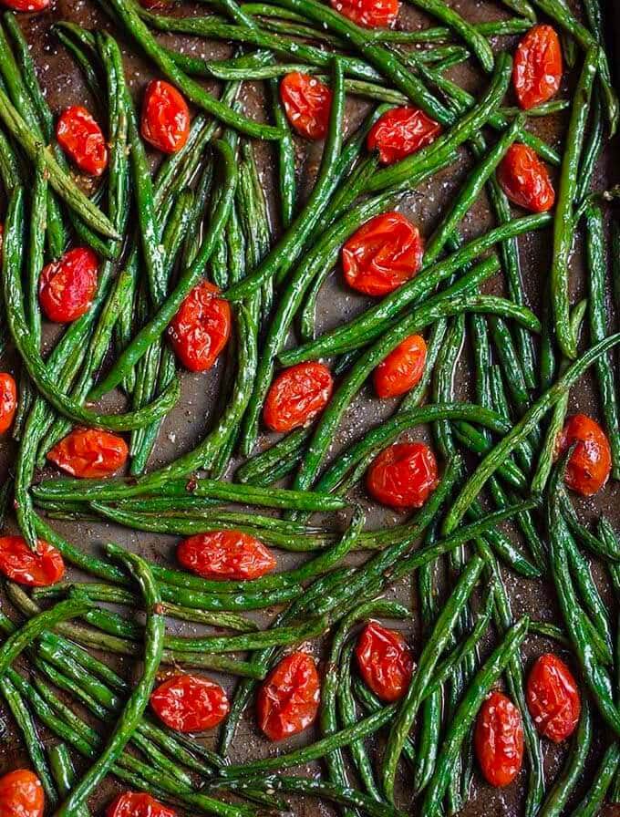 Spicy roasted green beans and tomatoes on a baking sheet