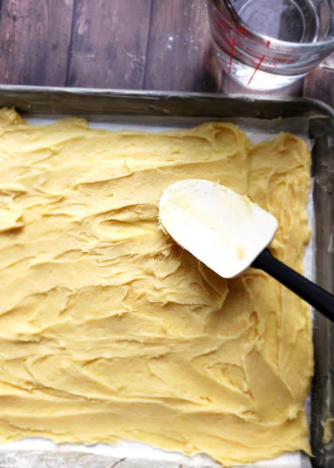 batter spread out on a baking sheet using a rubber spatula